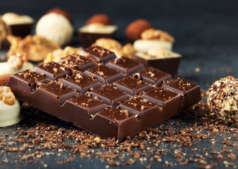 Bar of dark chocolate and candies with copy space