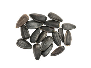 Some black sunflower seeds close together on white background seen from above