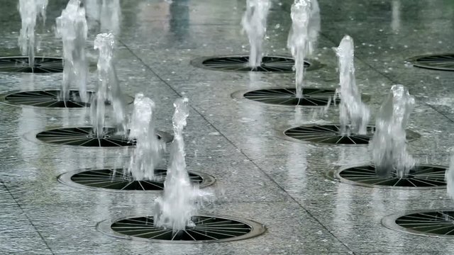 Row of water jets in a urban fountain.