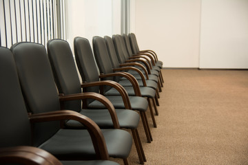 Leather black chairs are standing near the wall