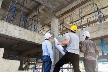 Engineer, foreman and worker discussing in building construction site
