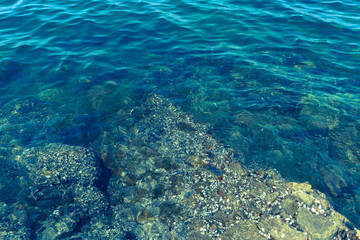 Fototapeta na wymiar The rocks along the blue ocean waters.
