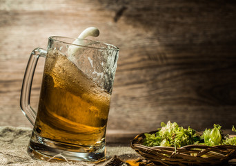 Beer spilling from cup on linen cloth