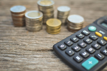 coin with  calculator on old wood background a color vintage tone