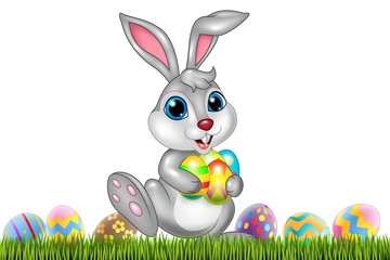 Easter bunny with decorated Easter eggs in a field