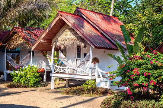 Small white bungalows with hammocks on the terrace in the tropic