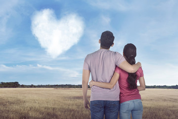 Young asian couple looking cloud with heart shape