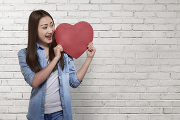 Obraz na płótnie Canvas Beautiful asian woman holding red heart