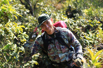 Man Traveler with backpack trekking in forest, Hikers trekking 
with backpacks in forest
