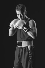 Young boxer sportsman on black background