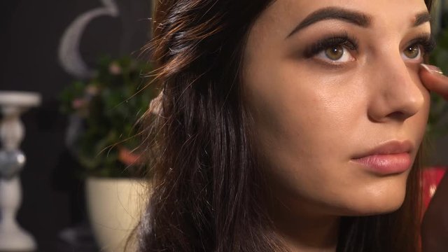 Makeup artist makes makeup for woman model