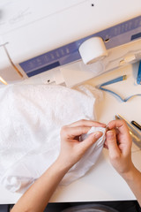 Girl in atelier unrips fabric