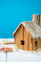 Homemade gingerbread house with glaze and confectionery sprinkling.