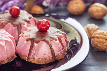 Raw vegan dessert made with sour cherry, dates and walnuts served on black plate