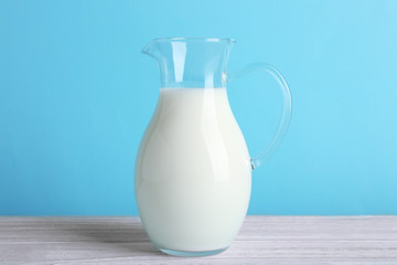 Jug of milk on white wooden table, closeup