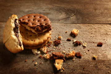 Tasty cookies with crumbs on wooden background