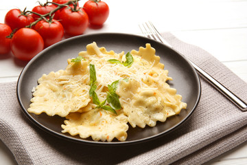 Plate of ravioli with cheese on table