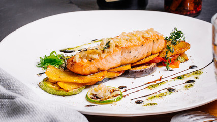 baked salmon with vegetables on glass plate isolated. Restaurant