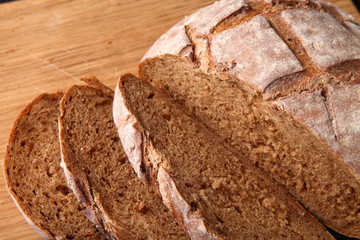bread, cut on an oak board/ bread, cut on an oak board on a dark background