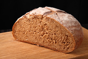 bread, cut on an oak board/ bread, cut on an oak board on a dark background