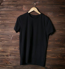 Blank black t-shirt against wooden background