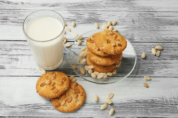 Peanut cookies with milk on wooden background