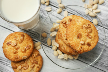 Peanut cookies with milk on wooden background