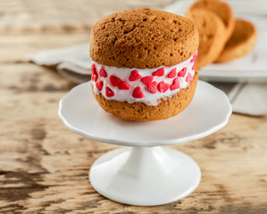 Ice cream cookie sandwich on stand on wooden background