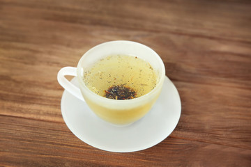 Glass cup of tea on wooden background