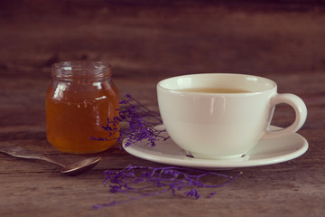 Obraz na płótnie Canvas Cup of tea with honey in jar on the wooden table