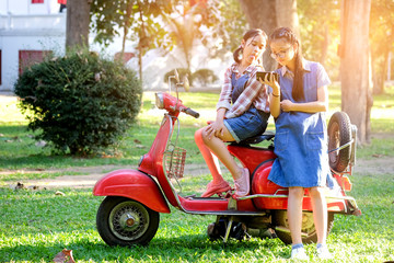 Asian children are sitting on the motorcycle.