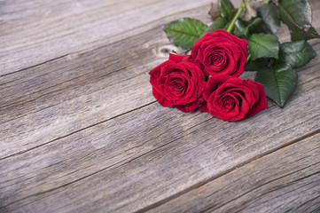 Red roses on a wooden boards.