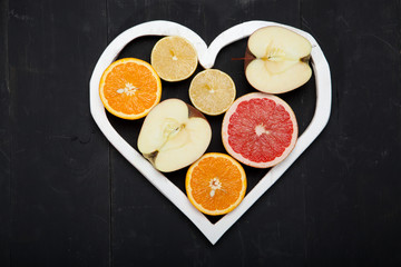 Fruits and heart on black background