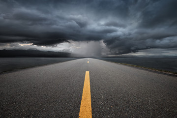 Empty highway leading to the mountains through the rain.