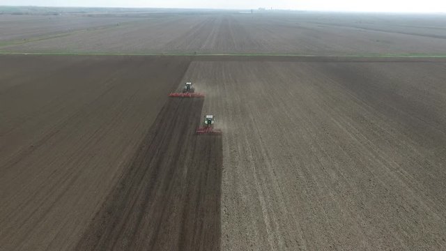 aerial view of a tractors plowing agriculture field
