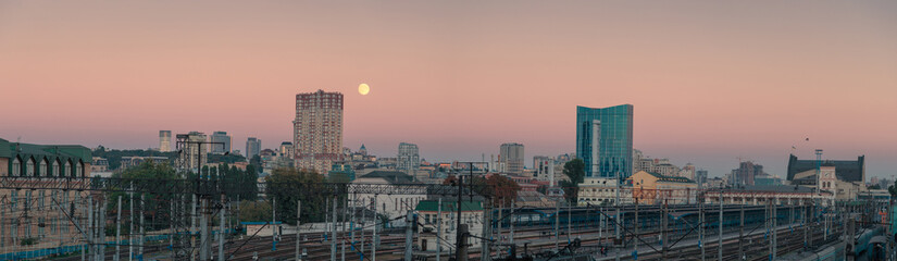 Fototapeta premium Moon over wide panorama of Kyiv city. Ukraine. Downtown and railways station.