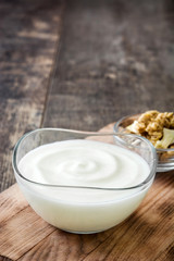Greek yogurt in glass bowl on wooden table
