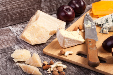 Fruits, nuts and cheese on wooden background
