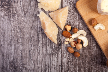 Obraz na płótnie Canvas Nuts and cheese on wooden background