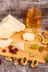 Honey, nuts and cheese on wooden background