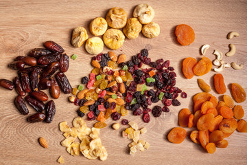 Dried fruits and nuts on wooden background