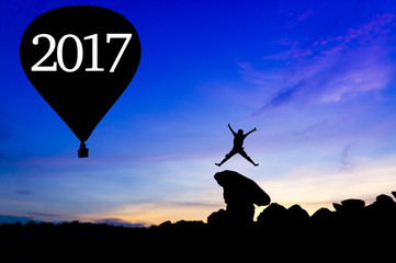 Silhouette man jumping between with 2017 hot air balloon wording.