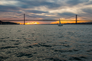 Sunset sky above Tagus River, Bridge April 25 Lisbon and  port at from ship, Portugal.