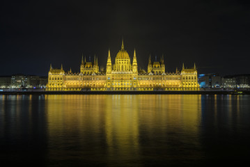 Fototapeta premium The view of Hungarian Parliament Building beside Danube River at Budapest, Hungary during night.