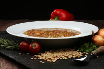Lentil soup with pita bread in a bowl on a wooden background
