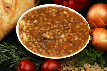 Lentil soup with pita bread in a bowl on a wooden background