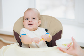 mother feeding her baby breast porridge day