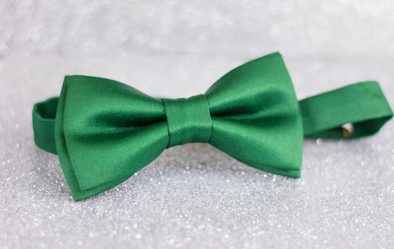 Green bow tie on silver background
