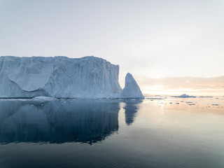 Fototapeta na wymiar Arctic Icebergs Greenland in the arctic sea. You can easily see that iceberg is over the water surface, and below the water surface. Sometimes unbelievable that 90% of an iceberg is under water