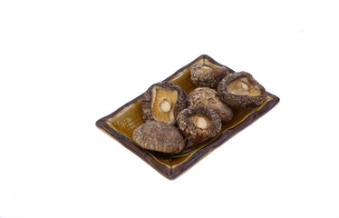 dry mushrooms shiitake on a plate isolated